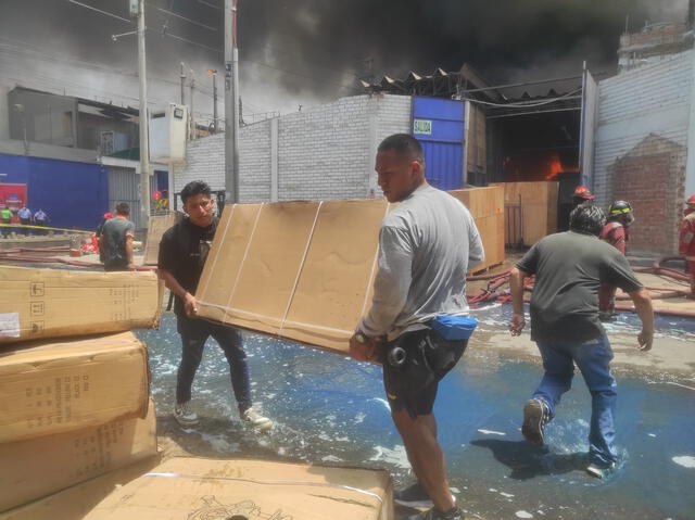Comerciantes intentan salvar sus productos frente al gigantesco incendio.