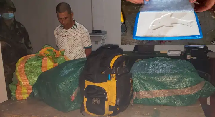El detenido  y los costales con la droga