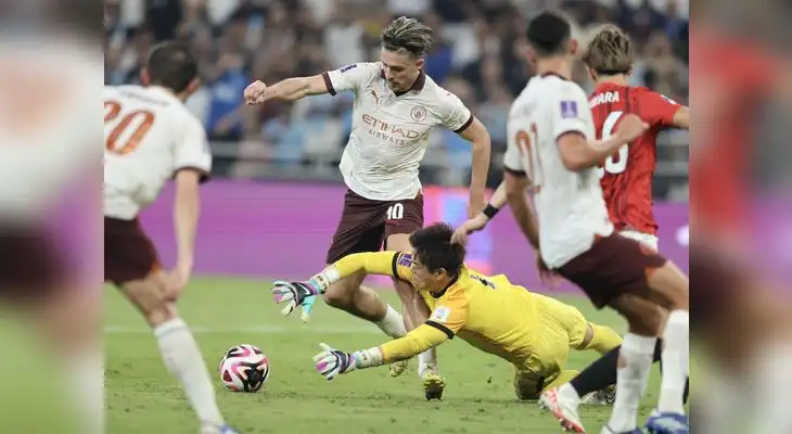 El portero Shusaku Nishikawa  trata de neutralizar al  delantero del City  Jack Grealish.